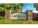 Community sign for Mirabella behind bushes and palm trees at 14318 Fissore Blvd, Wimauma, FL 33598