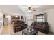 Open living area features modern seating, a ceiling fan, and seamlessly connects the living area to kitchen at 14318 Fissore Blvd, Wimauma, FL 33598