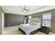 Main bedroom featuring a tray ceiling, a ceiling fan, and bright windows at 14318 Fissore Blvd, Wimauma, FL 33598