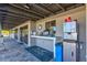 Outdoor bar area with coffee machines, cups, a trash can and a 'Landings Raquet Club' mat at 1447 Landings Cir # 68, Sarasota, FL 34231