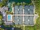 Aerial view of community tennis courts, pool, clubhouse, and landscaping at 1447 Landings Cir # 68, Sarasota, FL 34231