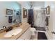 Bathroom featuring a vanity with a mirror, a toilet, and a walk-in shower with a glass door and marble wall at 1790 White Orchid Ct, Sarasota, FL 34235