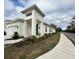 Contemporary white home with an attached garage, neat landscaping, and sidewalk at 1790 White Orchid Ct, Sarasota, FL 34235