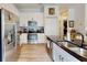 Bright kitchen featuring white cabinets, stainless steel appliances, and a black countertop at 1790 White Orchid Ct, Sarasota, FL 34235