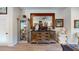 Living room with wood floors, cabinet with marble busts and mirror reflecting another room at 1790 White Orchid Ct, Sarasota, FL 34235