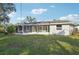 Lush green lawn and screened-in porch area in the backyard provides ample space for outdoor activities at 2079 Pellam Blvd, Port Charlotte, FL 33948