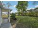 Screened-in porch extends to a spacious, grassy backyard with mature trees and natural landscaping at 2079 Pellam Blvd, Port Charlotte, FL 33948