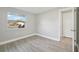 This bedroom features a window looking out onto a neighboring house with new wood look flooring at 2079 Pellam Blvd, Port Charlotte, FL 33948