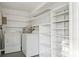 Well-lit laundry room features white appliances, white paint, and lots of shelving at 2079 Pellam Blvd, Port Charlotte, FL 33948