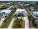 Aerial view of a single Gathering home with circular driveway and tropical landscaping at 221 Lychee Rd, Nokomis, FL 34275