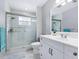 Clean bathroom with walk-in shower, white vanity, and large mirror at 221 Lychee Rd, Nokomis, FL 34275