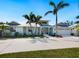 Light green house with palm trees and a large driveway at 221 Lychee Rd, Nokomis, FL 34275