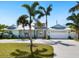 Spacious home with a large driveway, palm trees, and a two-car garage at 221 Lychee Rd, Nokomis, FL 34275