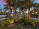 Landscaped front yard with palm trees and exterior lighting at 221 Lychee Rd, Nokomis, FL 34275