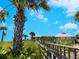 Picturesque beach path leading to a waterfront building under a clear blue sky at 221 Lychee Rd, Nokomis, FL 34275