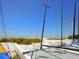 Sailboats on a sandy beach against a backdrop of blue sky and ocean at 221 Lychee Rd, Nokomis, FL 34275