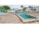 Community pool with a brick deck, poolside furniture, and a white fence at 2211 Sunset Dr # E3, Bradenton, FL 34207