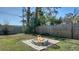 Enjoy a brick fire pit with wood surround in a fenced backyard at 2407 Amanda Dr, Sarasota, FL 34232