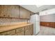 Kitchen featuring wood cabinets, tile backsplash, white appliances, and an adjacent dining area at 2407 Amanda Dr, Sarasota, FL 34232