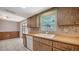 Kitchen featuring wood cabinets, white appliances, tile backsplash, and an adjacent dining area at 2407 Amanda Dr, Sarasota, FL 34232