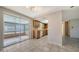 Bright kitchen featuring tile flooring, wood cabinets, and an adjacent sunroom with pool views at 2407 Amanda Dr, Sarasota, FL 34232