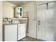 Laundry area with washer and dryer hookups, a hot water tank, and exterior access door at 2407 Amanda Dr, Sarasota, FL 34232