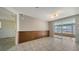 Living area featuring tiled floor and paneled accent wall with access to a screened lanai at 2407 Amanda Dr, Sarasota, FL 34232