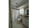 Clean, well-lit bathroom with white vanity, tile floor, and shower with white curtain at 2930 Tuckerstown Dr, Sarasota, FL 34231