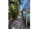 Walkway alongside screened in pool with tropical landscaping at 2930 Tuckerstown Dr, Sarasota, FL 34231