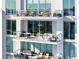 Stacked balconies furnished with comfortable seating, glass railings, and stylish planters overlooking the city at 301 Quay Commons # 1809, Sarasota, FL 34236