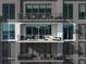 A view of balconies with glass railings that have cozy seating, and potted plants for relaxation and city views at 301 Quay Commons # 1809, Sarasota, FL 34236