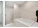 Bathroom featuring large tub, glass enclosed shower stall and tiled walls at 301 Quay Commons # 1809, Sarasota, FL 34236