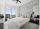 Bright bedroom with a large window view, plush carpet, and modern accent wall at 301 Quay Commons # 1809, Sarasota, FL 34236