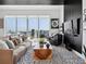 Modern living room with plush seating, striking rug, and city views from large window at 301 Quay Commons # 1809, Sarasota, FL 34236