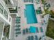 Aerial view of a stylish pool area with lounge chairs and lush landscaping at 301 Quay Commons # 1809, Sarasota, FL 34236