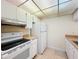 Cozy kitchen featuring white appliances, white cabinets, and neutral countertops at 3273 Beneva Rd # 101, Sarasota, FL 34232