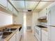 Kitchen featuring white appliances and cabinets and a double stainless steel sink at 3273 Beneva Rd # 101, Sarasota, FL 34232