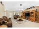 Living room with tiled floors, brown couches, and a large TV at 3273 Wentworth St, North Port, FL 34288