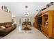 Living room with tiled floors, brown couches, and a large TV at 3273 Wentworth St, North Port, FL 34288