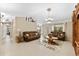 Living room with tiled floors, brown couches, and a large TV at 3273 Wentworth St, North Port, FL 34288