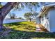 View of backyard with mature trees and new white vinyl fence at 3446 Monica Pkwy, Sarasota, FL 34235