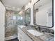 Remodeled bathroom features a large tiled shower and double granite vanity at 3446 Monica Pkwy, Sarasota, FL 34235