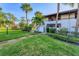 Exterior view of condo building with lush landscaping and walkway at 3500 El Conquistador Pkwy # 252, Bradenton, FL 34210