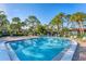 Inviting community pool with surrounding lounge chairs and lush landscaping at 3500 El Conquistador Pkwy # 252, Bradenton, FL 34210