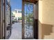 A detailed wrought iron door opens to a lush outdoor pool and patio entertainment area at 3628 Fair Oaks Pl, Longboat Key, FL 34228