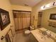 Cozy bathroom with framed art, neutral tile, and shower-tub combination with decorative curtain at 3739 Collins St # 701, Sarasota, FL 34232