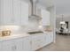 Bright kitchen with white cabinetry, subway tile backsplash, stainless steel appliances, and a view into the dining room at 3860 Santa Caterina Blvd, Bradenton, FL 34211