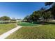 Landscaped putting green next to a pond and community buildings at 3990 Overlook Bnd # 19, Sarasota, FL 34232