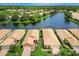 An aerial view of beautiful homes by the lake with tile roofs, a green lawn and landscaping at 4244 Reflections Pkwy, Sarasota, FL 34233