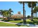 Clubhouse exterior surrounded by tropical landscaping and palm trees adds to the community's amenities at 4244 Reflections Pkwy, Sarasota, FL 34233